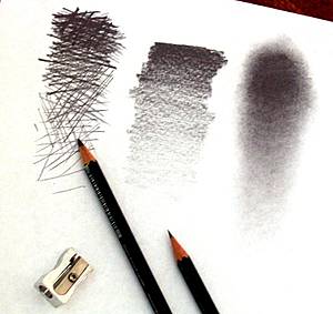 Fotografía de dos lápices de grafito y un afilador, sobre un papel con tres tipos de sombreado diferentes